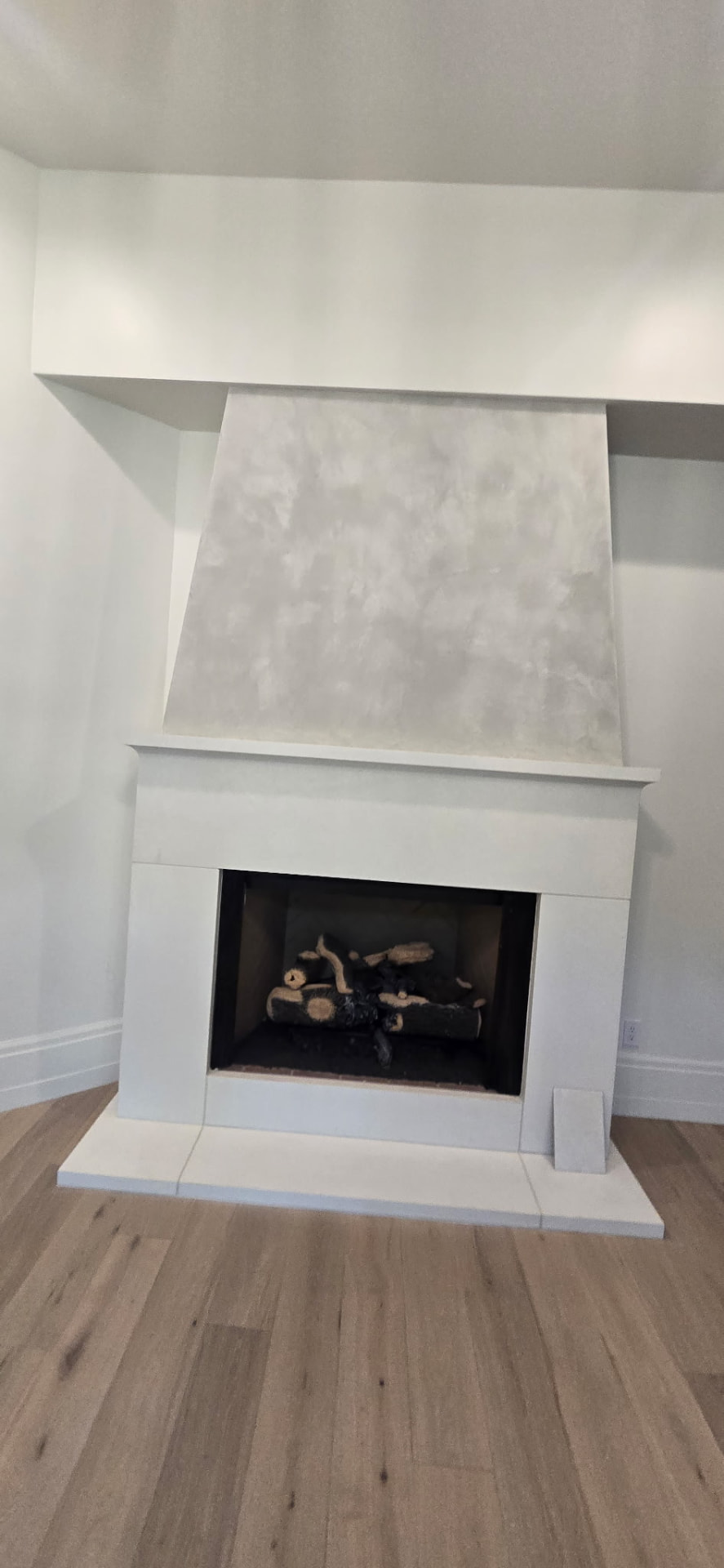 Fireplace surround and chimney breast finished in soft white Venetian plaster