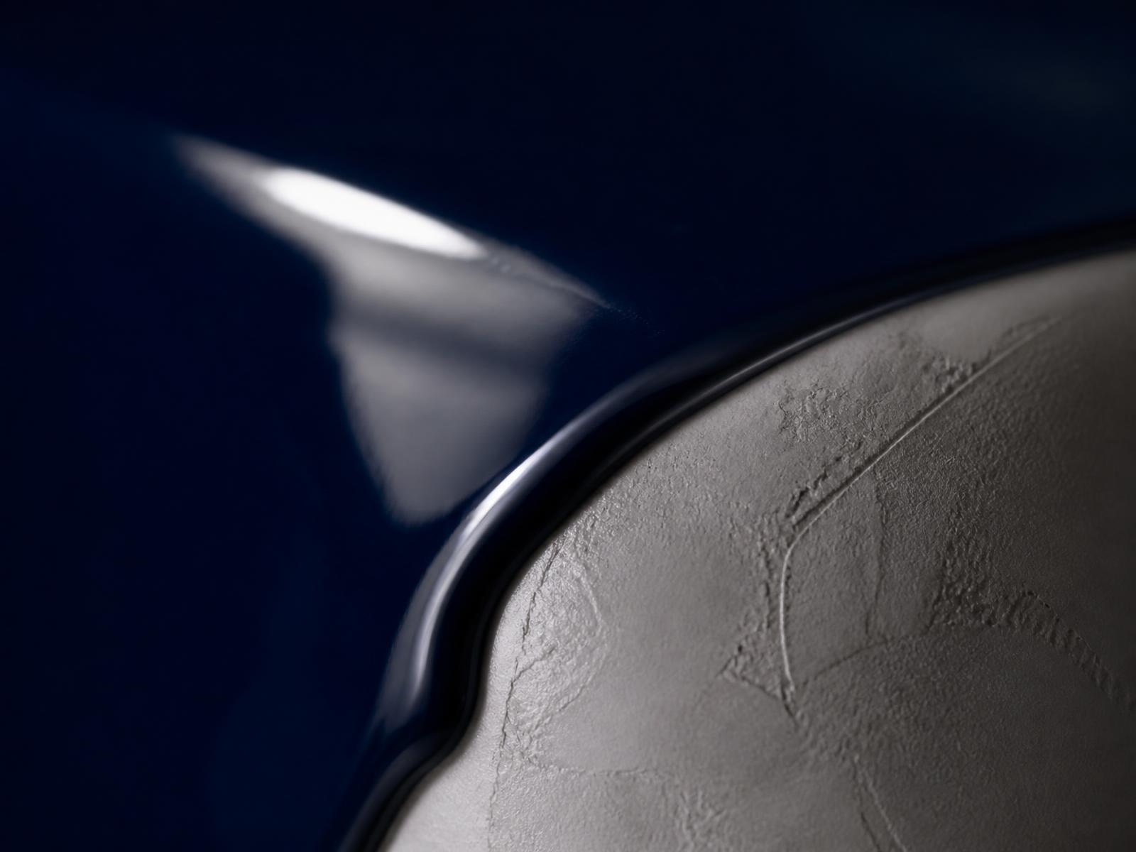 Close-up of a high-gloss lacquered surface meeting polished plaster